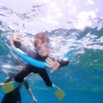 Best Things To Do in Cairns With Kids child swimming on The Great Barrier Reef near Cairns