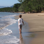 Things To Do in Port Douglas With Kids A child walking on Port Douglas Beach.